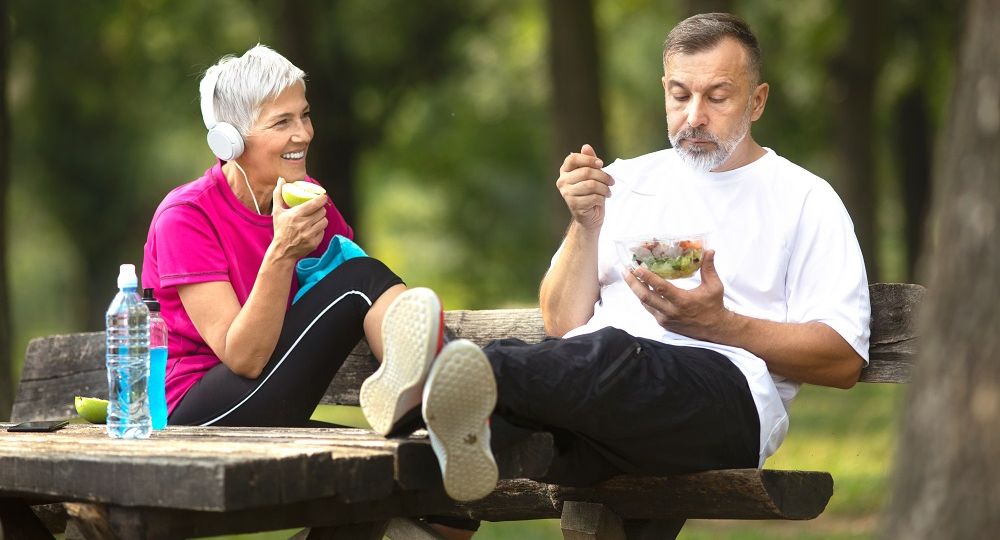 Senior couple taking a break from exercising outdoors