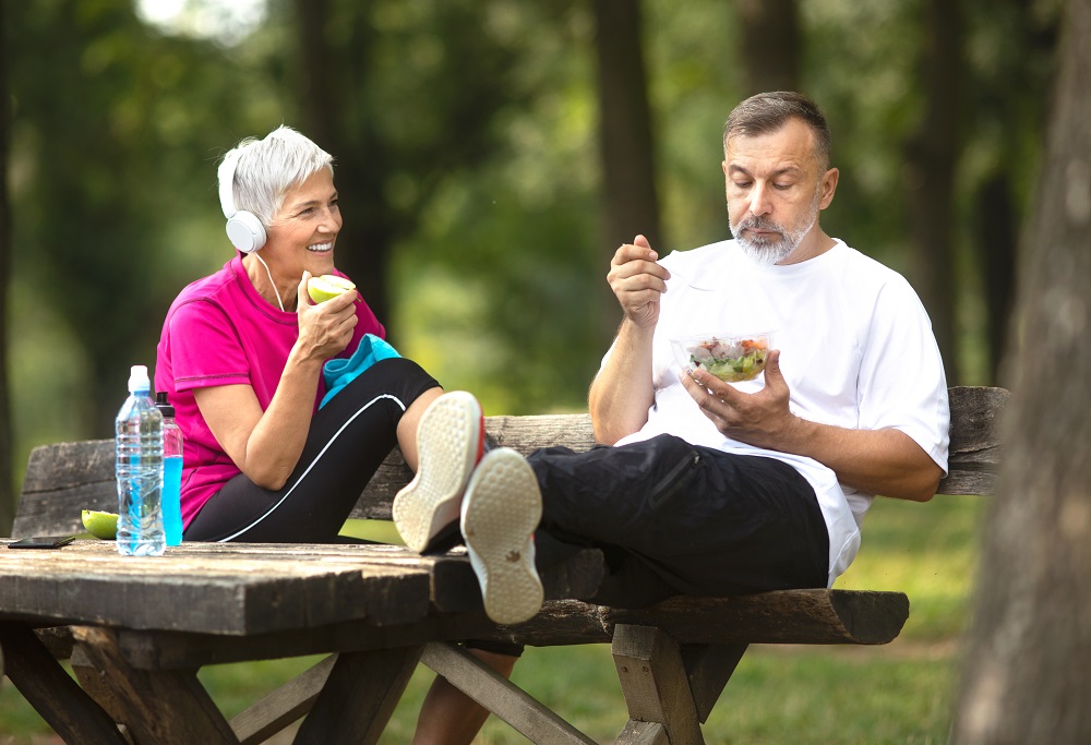Senior couple taking a break from exercising outdoors